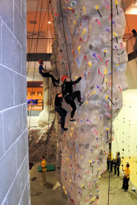 Team members at the climbing wall in the Wellness and Recreation Center during the Team Social.