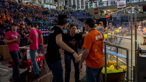 Three Alliance team members gathering in anticipation before a match.