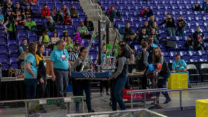 Team members moving their robot onto the field.