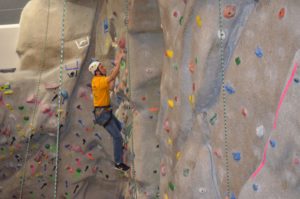 Team member climbing on the UNI Rock Climbing wall.