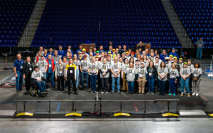 group photo of about 100 volunteers on the stage