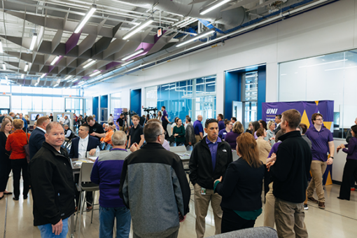 A large event taking place in the John Deere Innovation Corridor with many people moving about a large space.