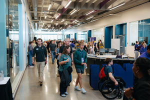 View two of a large event taking place in the John Deere Innovation Corridor with many people moving about a large space.